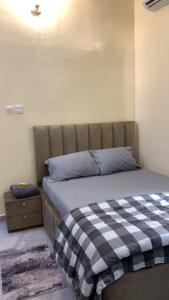 a bedroom with a bed with a checkered blanket at Crystal Apartment in Ofada