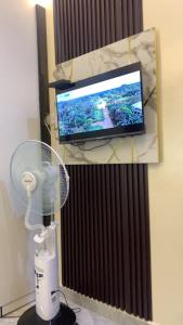 a room with a fan and a television at Crystal Apartment in Ofada