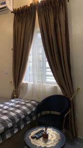 a bedroom with a bed and a table and a chair at Crystal Apartment in Ofada