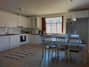 a kitchen with a dining room table and chairs at Kuivasjärvi House in Oulu