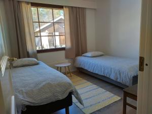 a bedroom with two beds and a window at Kuivasjärvi House in Oulu