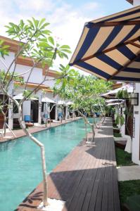 a swimming pool with an umbrella next to a resort at Jali Resort - Gili Trawangan in Gili Trawangan