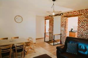 a living room with a table and a brick wall at La batisse du Champ Manneret Maison d'hôte Falaise - logement entier in Falaise +19 photos