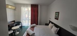 a bedroom with a bed and a desk and a window at Family нouse -Нotel Asai in Ravda +71 photos