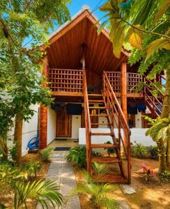 a house with a wooden staircase in front of it at Beach Wave Hotel in Arugam Bay