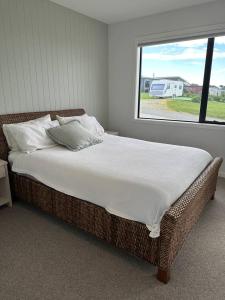 a large bed in a bedroom with a window at Coastal Luxe Villa in Kakanui