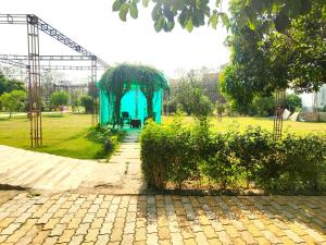 a blue pavilion in a park with a playground at Nature Homestay in Varanasi +23 photos