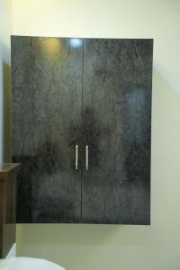 a bathroom with a black cabinet with silver handles at VS Residency in Elūru