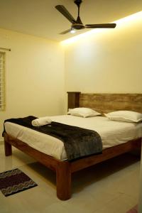 a bedroom with a bed with a ceiling fan at VS Residency in Elūru