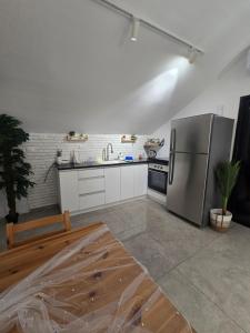 eine Küche mit einem Edelstahlkühlschrank und einer Spüle in der Unterkunft הסוויטה בטיילת in Aschdod + 13 Fotos
