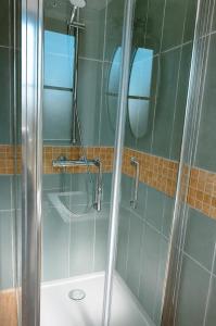 a bathroom with a shower with a glass door at La batisse du Champ Manneret Maison d'hôte Falaise - logement entier in Falaise
