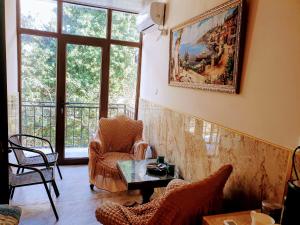 a living room with a table and chairs and a painting at Hotel Royal in Kutaisi