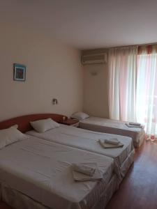 two beds in a hotel room with towels on them at Къща за Гости ,,Afrikana,, in Sveti Vlas