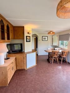 a kitchen with a table and a dining room at Simene cabin in Bridport