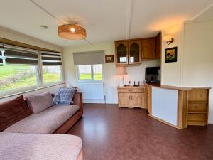 a living room with a couch and a kitchen at Simene cabin in Bridport +13 photos