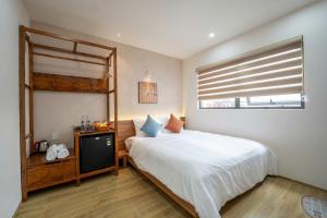 a bedroom with a large bed and a window at MIRO Homestay in Hue