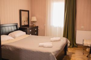 a bedroom with a bed with two towels on it at Bethlehem Terrace in Tbilisi City