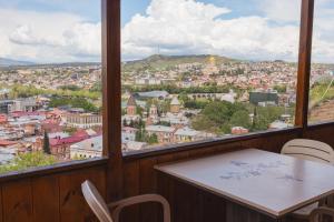 a table and chairs in a room with a view of a city at Bethlehem Terrace in Tbilisi City