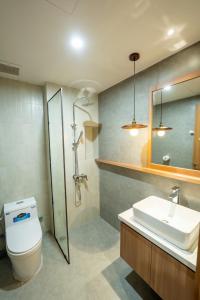 a bathroom with a toilet and a sink and a shower at MIRO Homestay in Hue