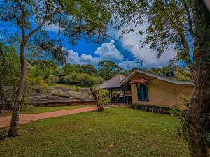 a house with a tree in the yard at Galpothuyaya Eco Lodge Kandalama in Dambulla