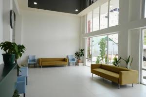 a waiting room with couches and tables and windows at Toma Palace in Makhinjauri