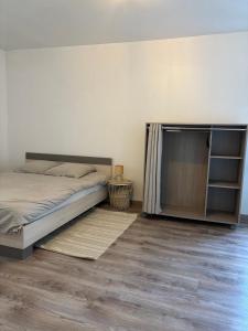 a bedroom with a bed and a wooden floor at Domino in Vaucouleurs