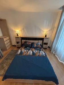 a bedroom with a blue bed and two night stands at Domino in Vaucouleurs