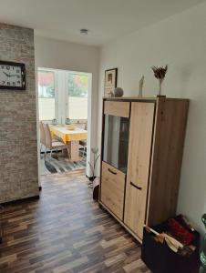 a living room with a cabinet and a dining room at Apfelhof Rüdersdorf in Rüdersdorf