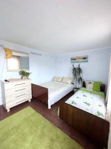 a bedroom with two beds and a dresser at Лана бугаз in Karolino-Buhaz