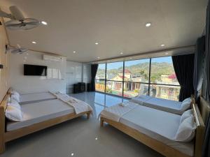 a bedroom with two beds and a large window at Motel Mỹ Linh 976 in Long Hai