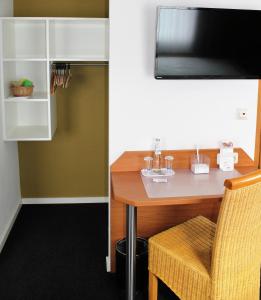 a dining room table with a chair and a television at Hotel & Restaurant Hüllen in Barweiler