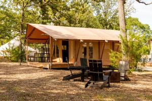 a tent with a table and a chair in front of it at Glamping Tent, Hike, Smore Vibes in Branson