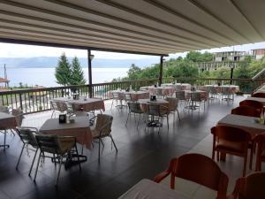 a restaurant with tables and chairs on a balcony at Hotel Makpetrol Struga in Struga