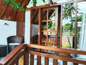 a room with a wooden balcony with a large window at Nan Bungalows Tetebatu in Tetebatu