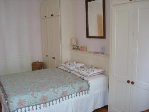 Dormitorio pequeño con cama y espejo en Luxury Holland Park, sleeps 2, Free S'fast WiFi, en Londres
