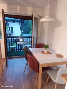 a dining room with a table and chairs and a balcony at Appartement Vignec proche Saint-Lary in Vignec