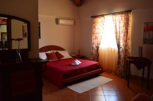 een slaapkamer met een rood bed en een raam bij B&B Antico Frantoio in Sambuca di Sicilia