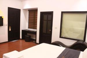 a room with two doors and a bed in it at Pickle Hotel Từ Sơn in Ðại Sơn