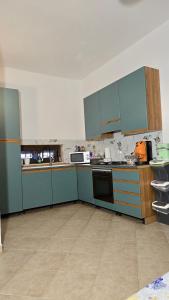 an empty kitchen with blue cabinets and appliances at Holiday in Paradise in Balestrate +7 photos