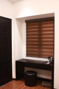 a room with a window with a table and a stool at Pickle Hotel Từ Sơn in Ðại Sơn