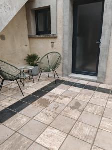 two chairs and a table on a patio at Appartements à Evron in Évron