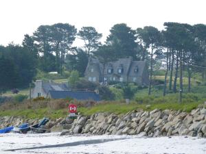 a house sitting on the shore of a beach at Chambres d hôtes vue mer au gré des marées Plouguerneau Bretagne in Plouguerneau