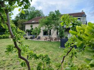 a stone house with a garden in front of it at Cidre Bois in Saint-Sulpice-le-Dunois