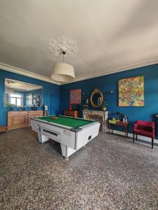 a living room with a pool table and blue walls at Rosemar in Peyriac-de-Mer