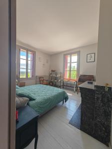 a bedroom with a bed and a table and windows at Rosemar in Peyriac-de-Mer