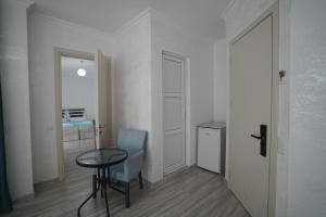 a room with a table and a chair and a table and a door at Toma Palace in Makhinjauri