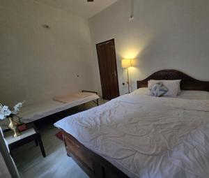 a bedroom with a large bed and a bench in it at SS Hostel in Siliguri