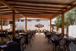 a group of tables and chairs in a pavilion at Hotel Stella Del Sud in Calasetta