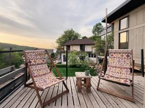 two chairs and a table on a deck at Alexa Mountain Homes in Kok-Shoky