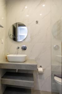 a bathroom with a sink and a mirror at Wilde Rose Hotel in Dassia +42 photos